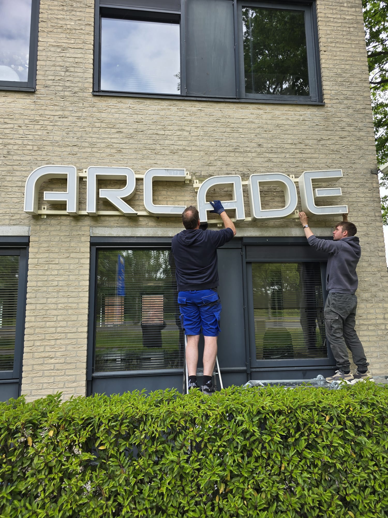 Arcade Bouwkwaliteit verhuisd - Losschroeven letters rechterkant