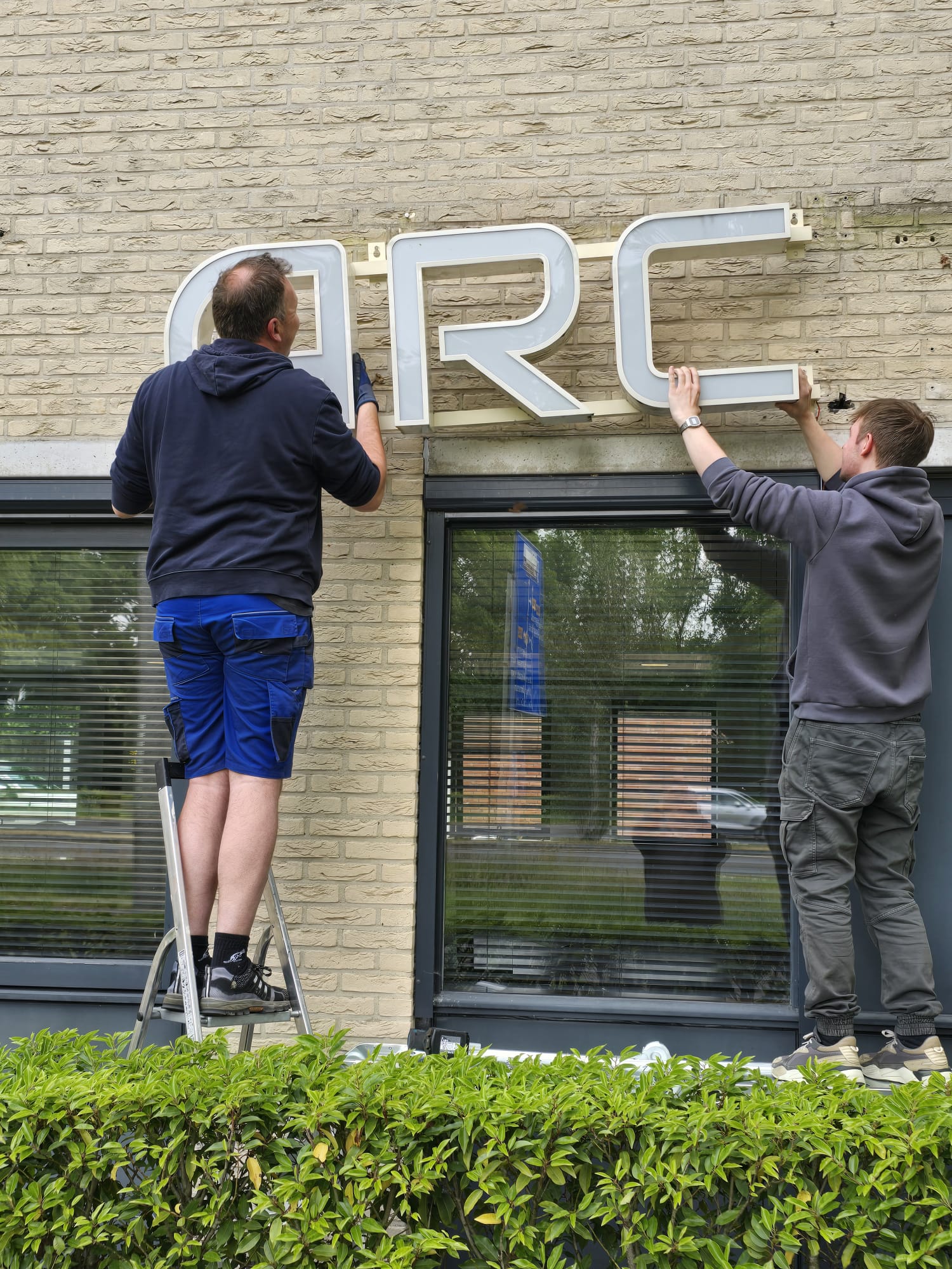 Arcade Bouwkwaliteit verhuisd - Losschroeven letters linkerkant